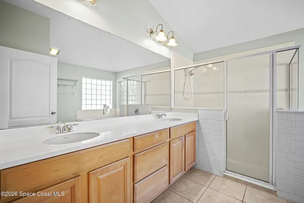 a bathroom with a double vanity sink a mirror and a shower