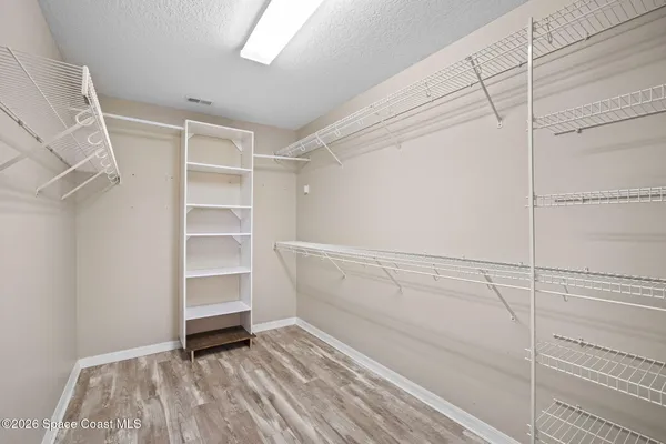 a view of walk in closet with empty racks