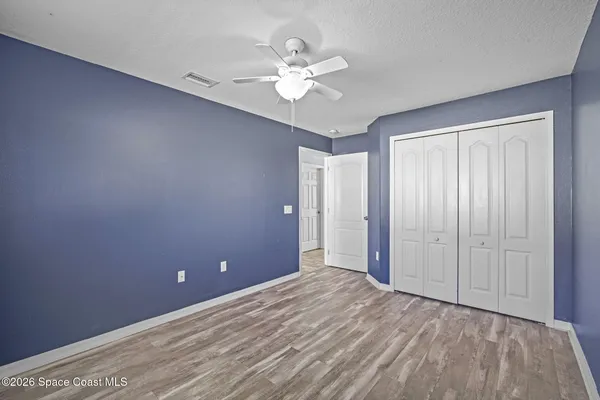 wooden floor in an empty room with a ceiling fan