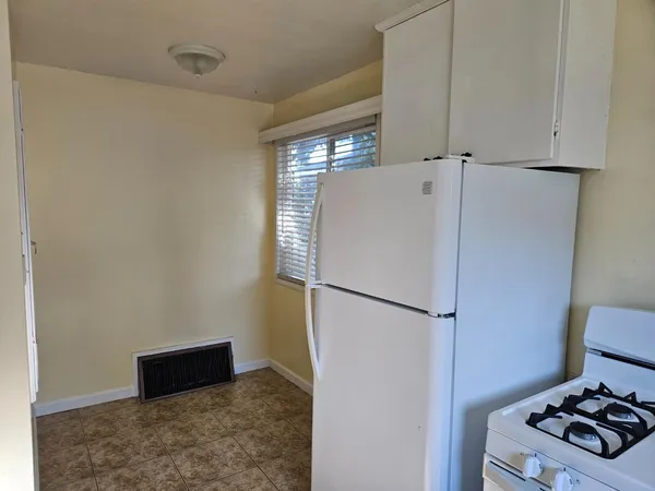 a white refrigerator freezer and a stove sitting inside of a kitchen