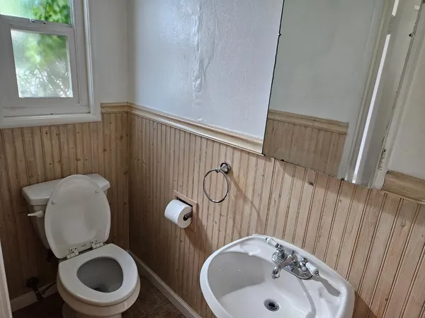 a bathroom with a toilet sink and mirror