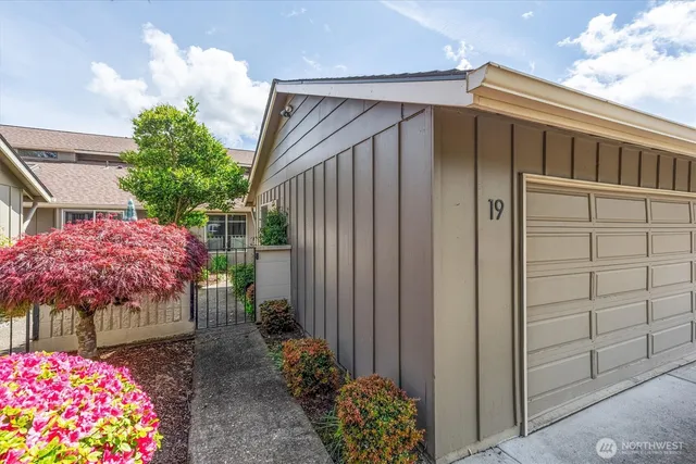 a view of a house with a yard and potted plants