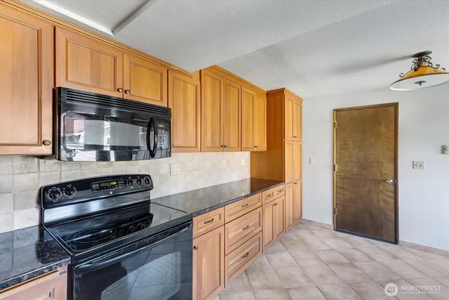 a kitchen with granite countertop a stove and a microwave