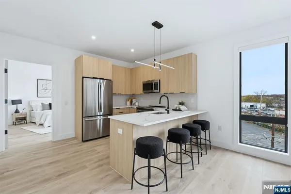 a kitchen with a refrigerator a sink dishwasher a stove and a refrigerator with wooden floor