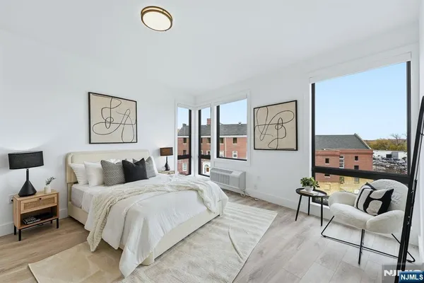 a bedroom with a bed a couch and painting on the wall