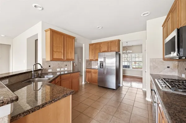 a kitchen with stainless steel appliances granite countertop a sink stove and refrigerator