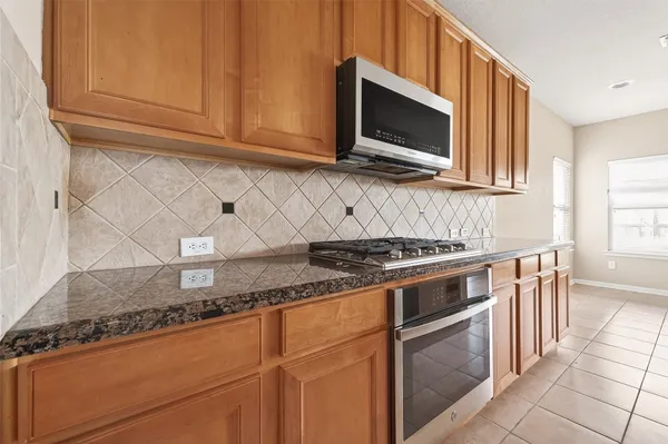 a kitchen with granite countertop cabinets stainless steel appliances and wooden cabinets