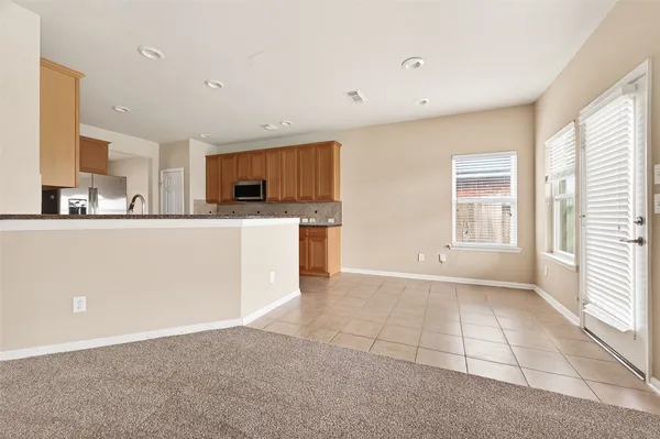 a view of a kitchen with kitchen island and stainless steel appliances