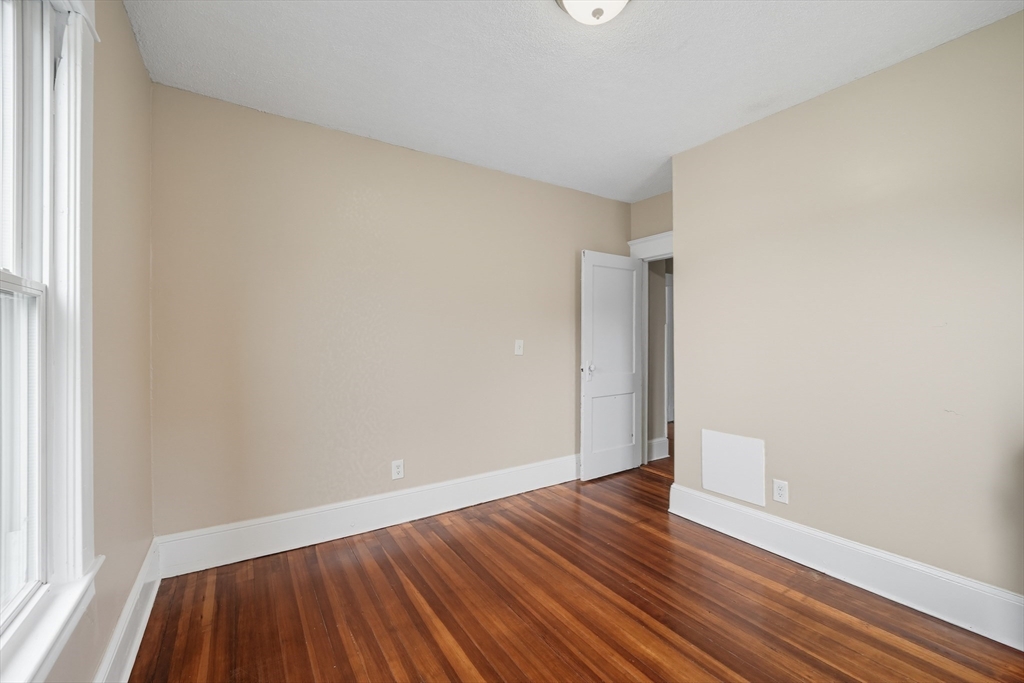 32 Santa Barbara Street, Unit 32 Springfield, MA 01104 - Photo 11 of 21 a view of an empty room with wooden floor and a window