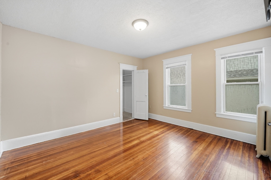 32 Santa Barbara Street, Unit 32 Springfield, MA 01104 - Photo 12 of 21 a view of an empty room with wooden floor and a window