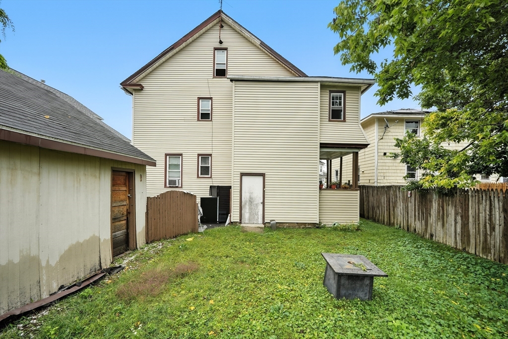 32 Santa Barbara Street, Unit 32 Springfield, MA 01104 - Photo 20 of 21 a view of backyard of house with wooden fence and a large tree