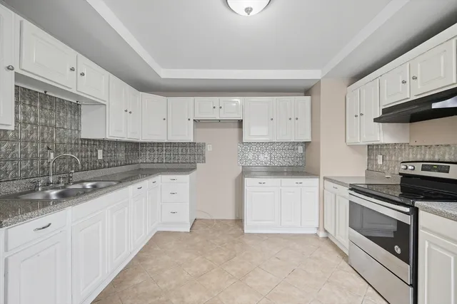 a kitchen with granite countertop white cabinets and white appliances
