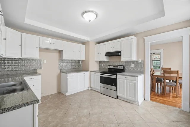 a kitchen with granite countertop a stove and a refrigerator