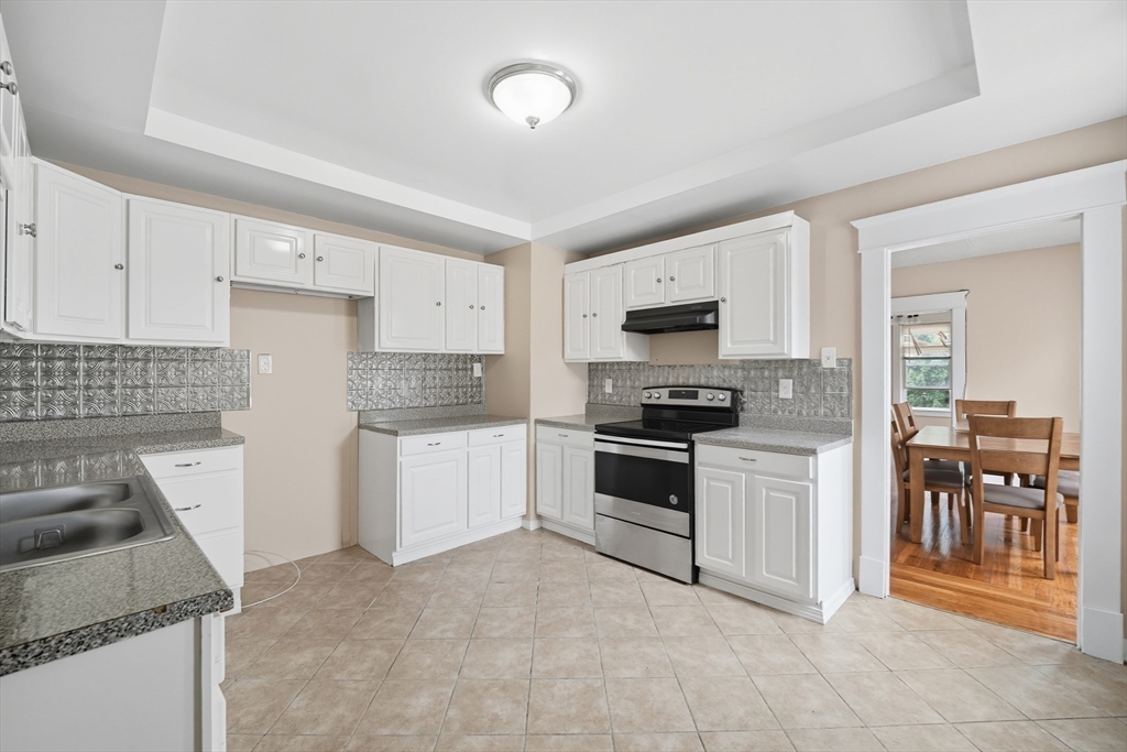 32 Santa Barbara Street, Unit 32 Springfield, MA 01104 - Photo 5 of 21 a kitchen with granite countertop a stove and a refrigerator