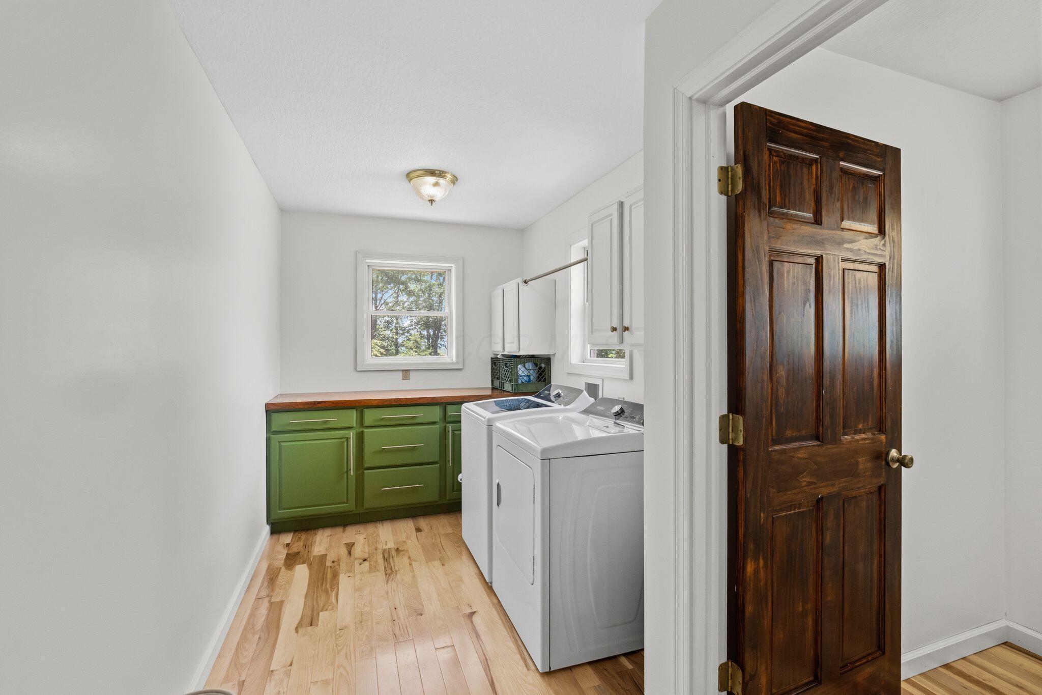 10446 Rich Hollow Road Southwest Lancaster, OH 43130 - Photo 22 of 83 Utility room featuring wood-finish flooring, a window, green cabinetry with a wood countertop, and a ceiling-mounted light fixture