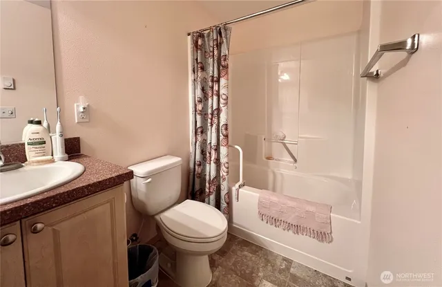a bathroom with a granite countertop sink toilet and shower