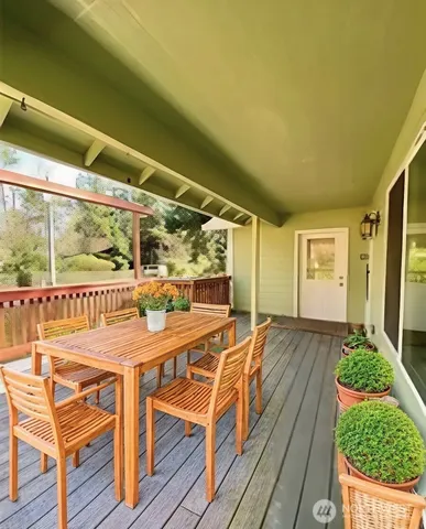 a view of a patio with table and chairs with wooden floor and fence