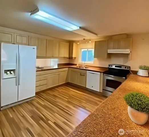 a kitchen with stainless steel appliances granite countertop a sink stove and refrigerator