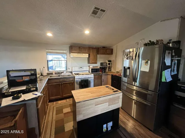 a kitchen with a refrigerator stainless steel appliances counter space and a window