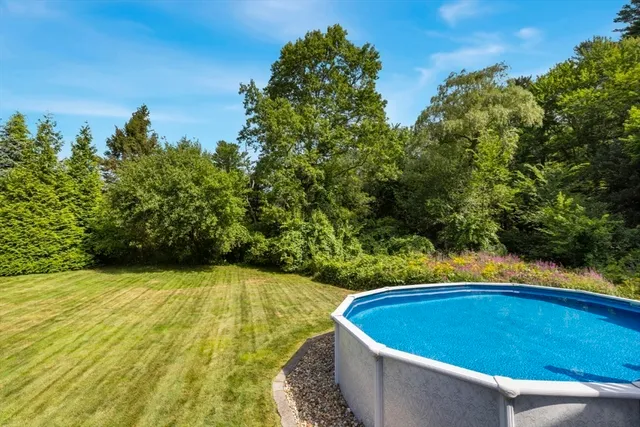 a backyard of a house with lots of green space and fountain