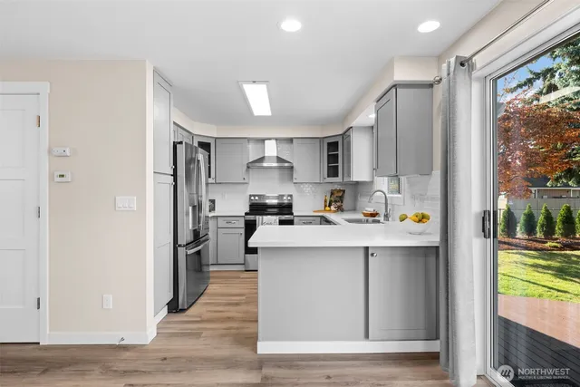 a kitchen with stainless steel appliances a sink stove and refrigerator
