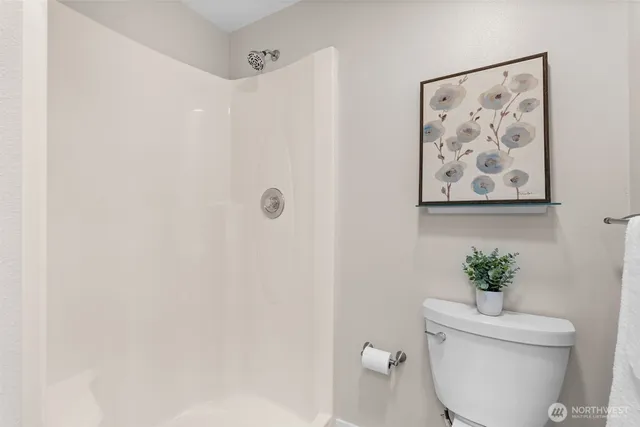 a bathroom with a granite countertop shower and a toilet