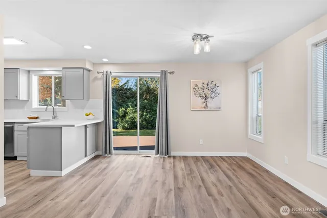 a view of a hallway with wooden floor and a window