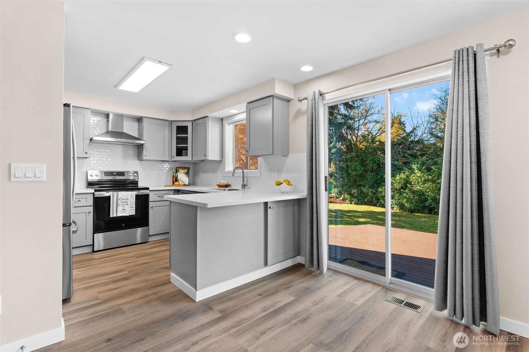 720 7th Street Southwest Puyallup, WA 98371 - Photo 10 of 40 a kitchen with a refrigerator a sink and a large window