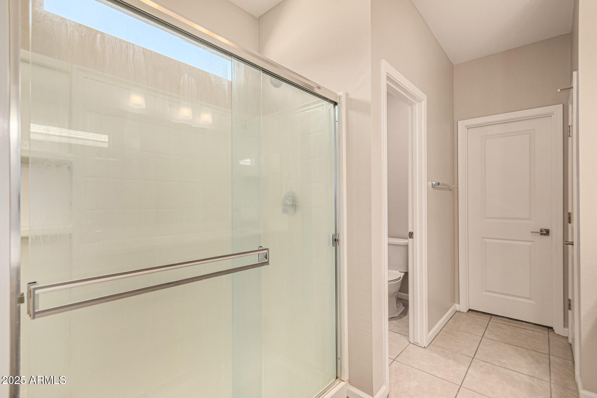 17320 West Daley Lane Surprise, AZ 85387 - Photo 20 of 46 a bathroom with a shower and a glass door