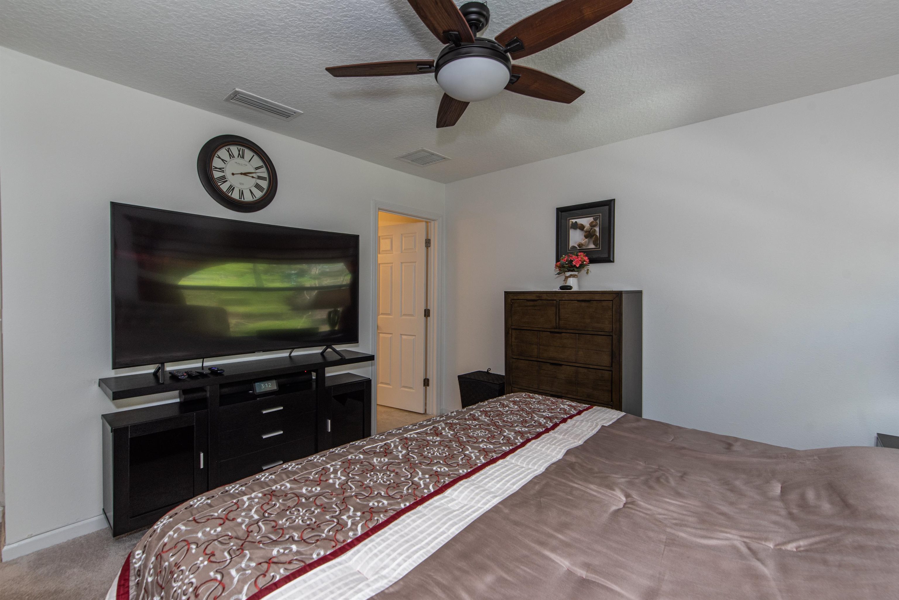 18 Ridge Lake Road St. Augustine, FL 32086 - Photo 29 of 47 a bedroom with a bed and a flat tv screen on dresser