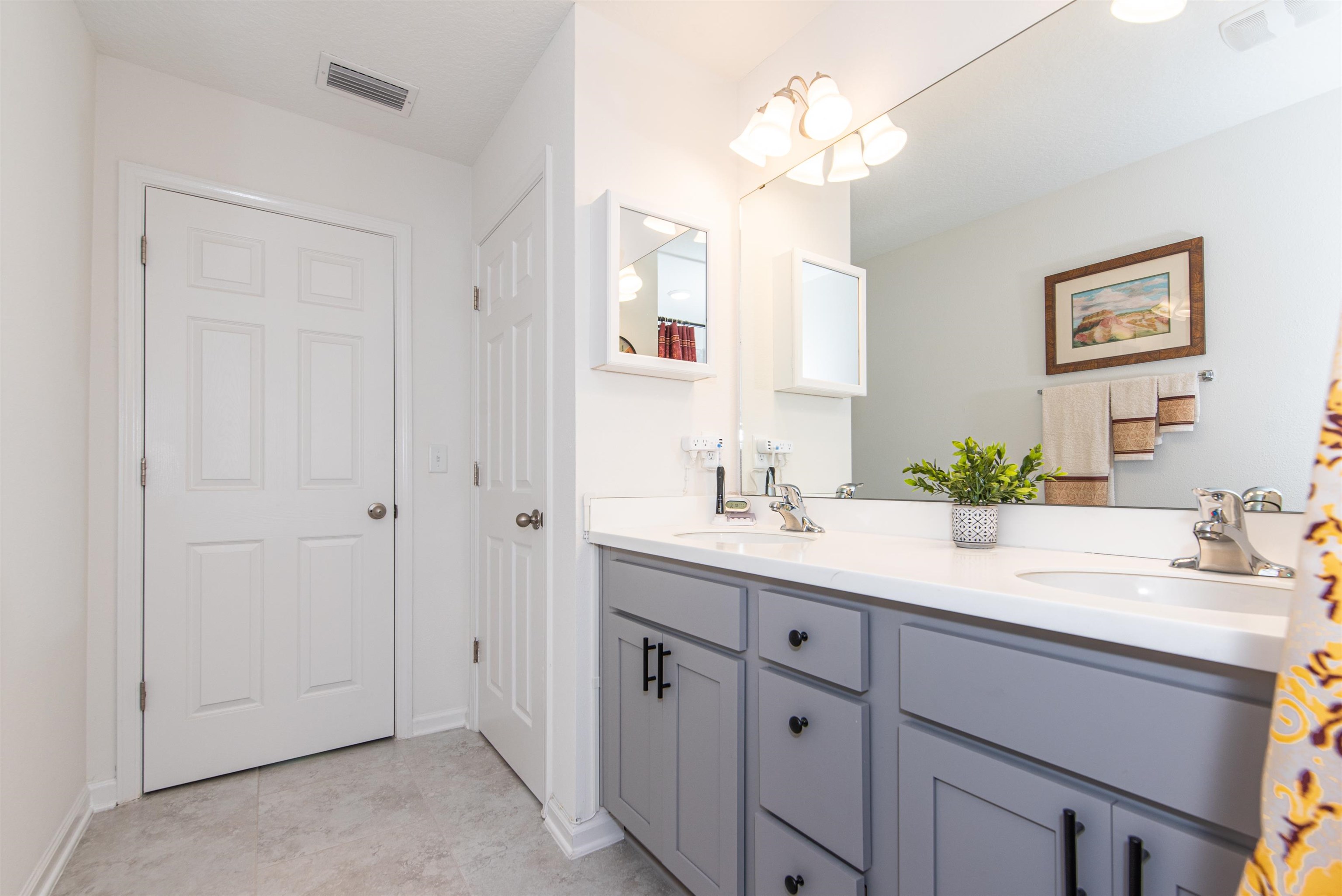 18 Ridge Lake Road St. Augustine, FL 32086 - Photo 32 of 47 a bathroom with a sink vanity and a mirror