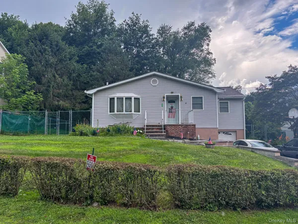 a front view of a house with a yard and trees