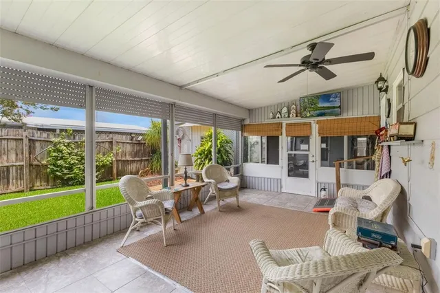 a living room with patio furniture and a floor to ceiling window