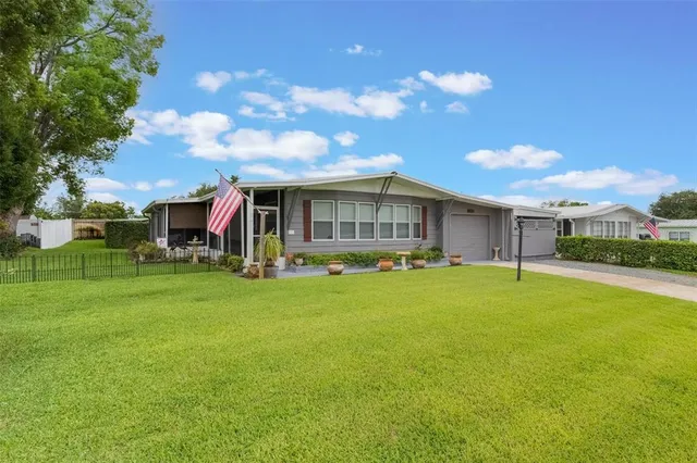 a view of a house with a big yard and a large tree