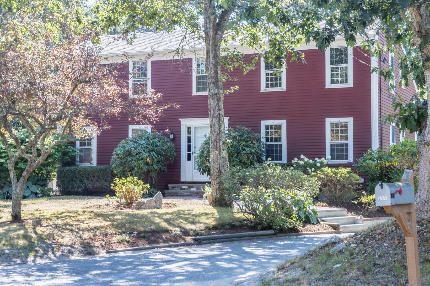 a view of a brick house with a yard and plants