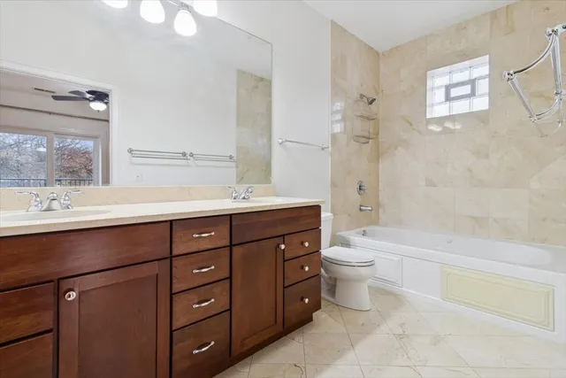 a view of an empty room with wooden floor and a ceiling fan