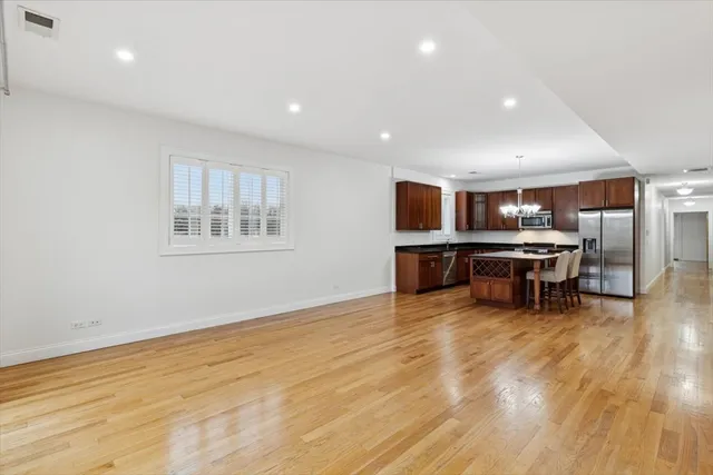 a kitchen with stainless steel appliances a table chairs refrigerator and microwave