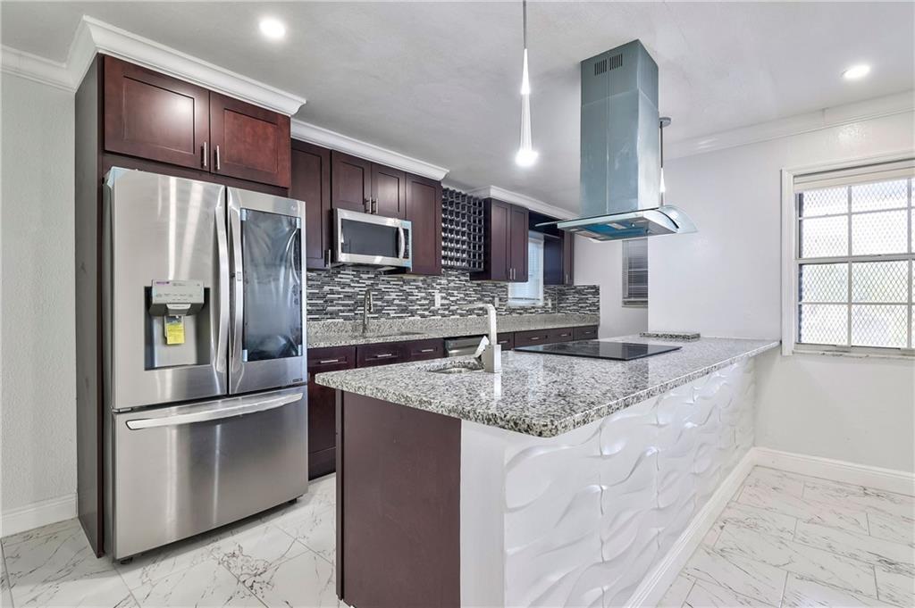 1389 West 33rd Street Riviera Beach, FL 33404 - Photo 4 of 20 a kitchen with stainless steel appliances granite countertop a sink and a refrigerator