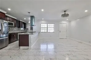 a large kitchen with kitchen island granite countertop a large counter top stainless steel appliances and cabinets