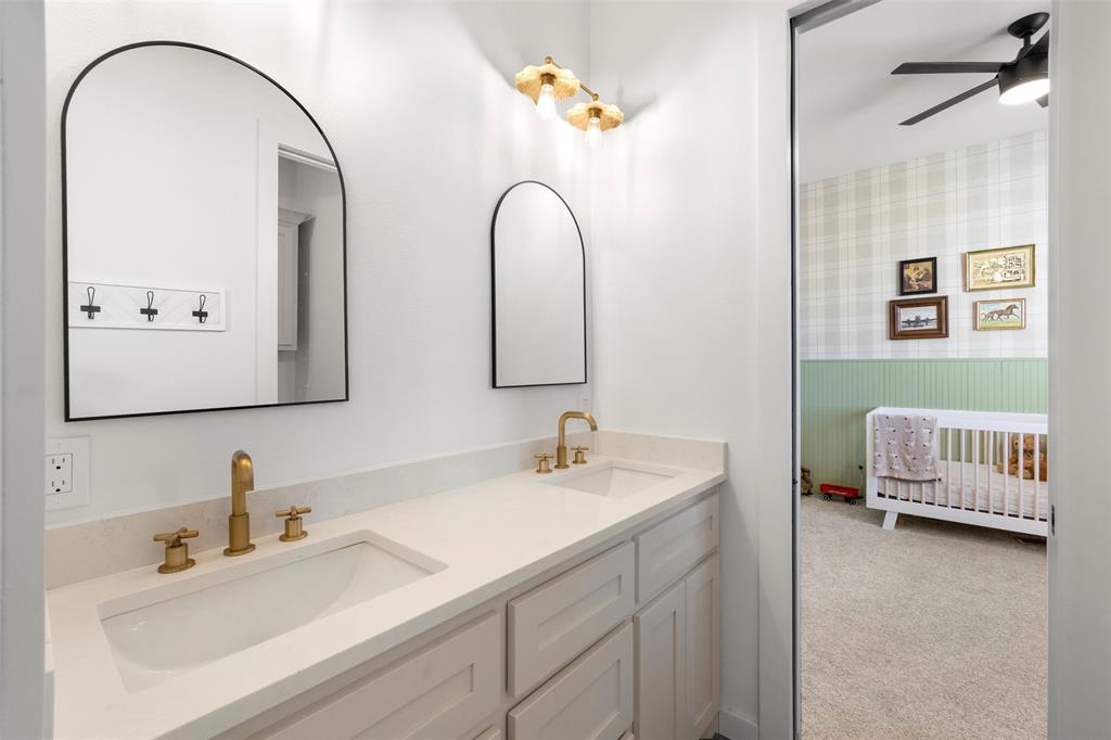 861 Brindley Road Maypearl, TX 76064 - Photo 23 of 36 Dual vanity with integrated sinks, gold-finish fixtures, arched mirrors, and white cabinetry