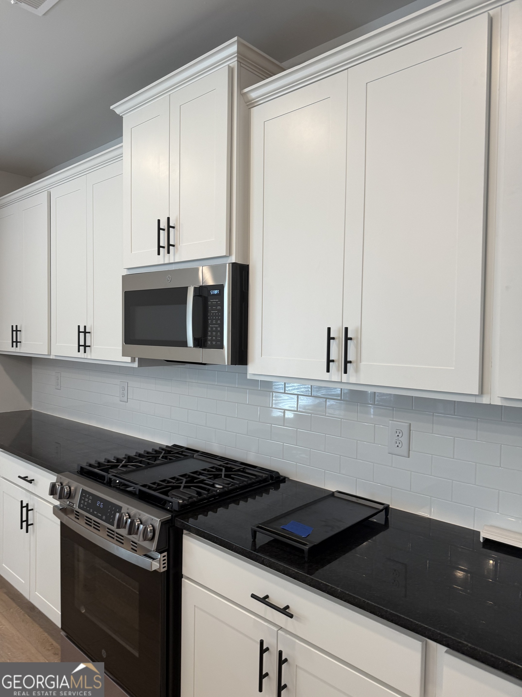 210 Villa Rica Springs Villa Rica, GA 30180 - Photo 5 of 24 a kitchen with granite countertop white cabinets and black appliances