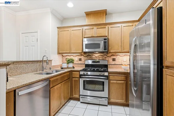 a kitchen with stainless steel appliances granite countertop a refrigerator stove and sink