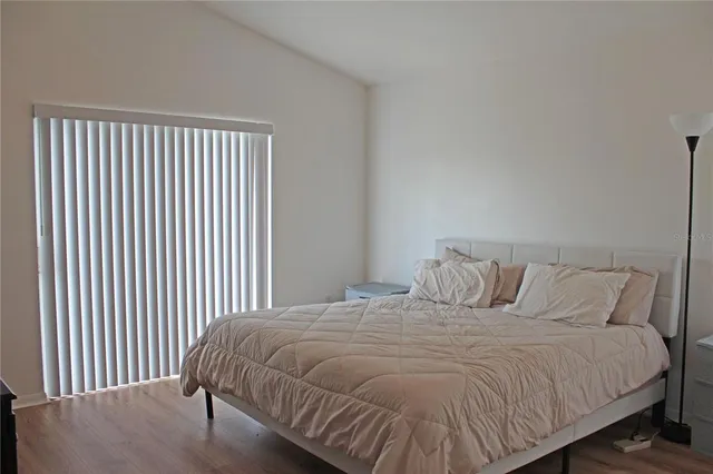 a large bed sitting in a bedroom next to a window