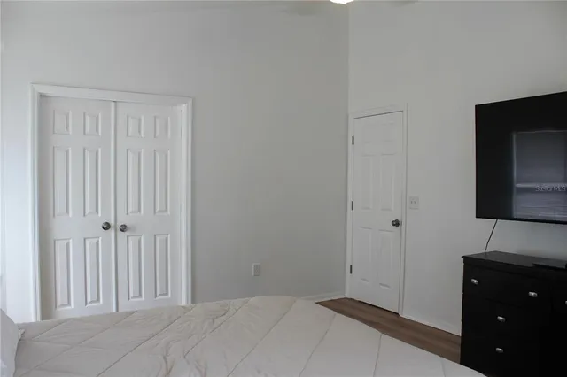 a bedroom with a bed and a flat tv screen on a dresser