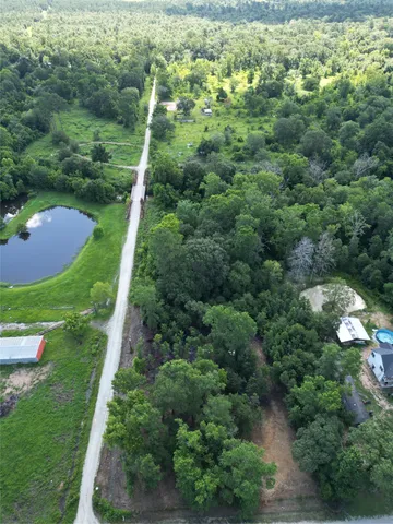 an aerial view of residential houses with outdoor space and trees