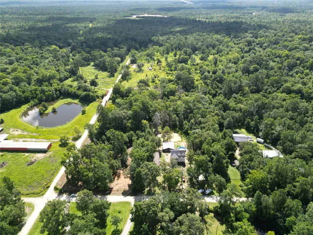 an aerial view of residential houses with outdoor space and trees
