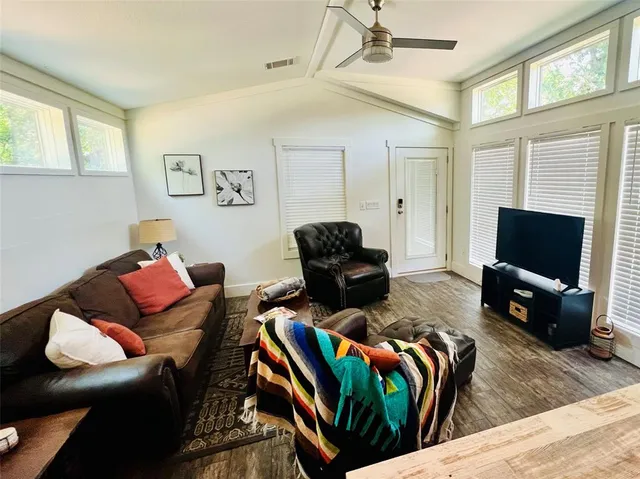 a living room with furniture a flat screen tv and a window
