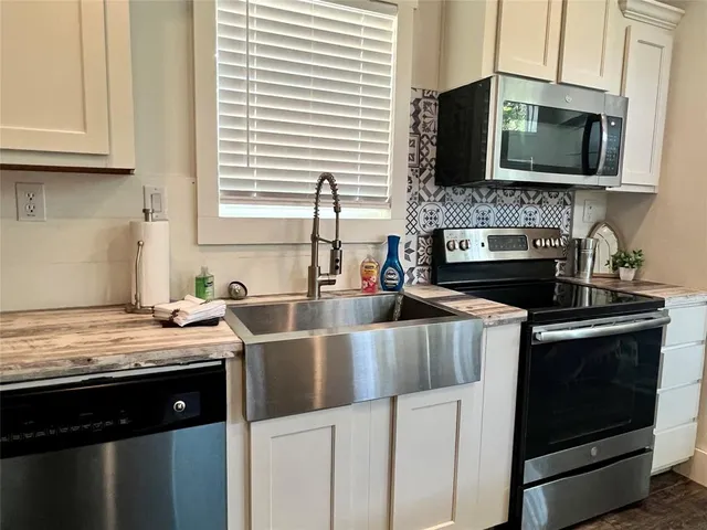 a kitchen with stainless steel appliances granite countertop a sink stove and microwave