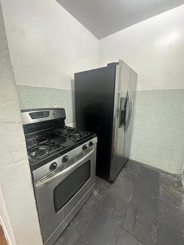 a metallic refrigerator freezer sitting in a kitchen