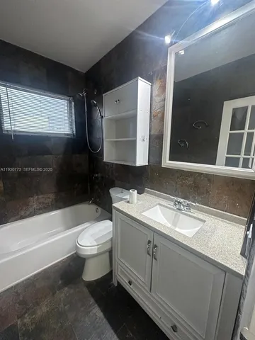 a bathroom with a double vanity sink toilet and mirror